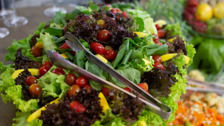 Vibrant mixed green salad with cherry tomatoes and fresh vegetables, perfect for a healthy meal.
