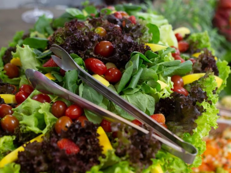 Vibrant mixed green salad with cherry tomatoes and fresh vegetables, perfect for a healthy meal.